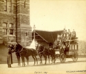 sepia photograph of Football fans leaving campus on Thanksgiving Day, 1894. football fans are sitting atop a horse-drawn carriage in front of Healy hall. 