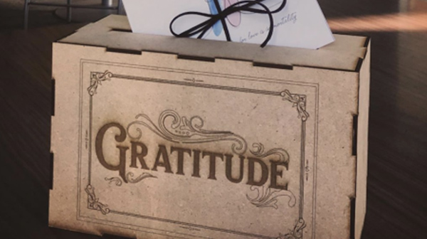 Laser cut box with the word "Gratitude" cut into the side. 