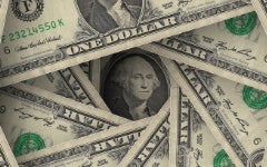 A stack of dollar bills arranged in a spiral, showing the central portrait of George Washington in the center