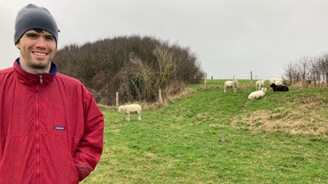 Scott Tyson in a field with sheep