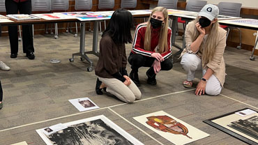 Students (from left) Chloe Akazawa, Olivia Giampietro, and Beatriz Areizaga plan the exhibition layout.
