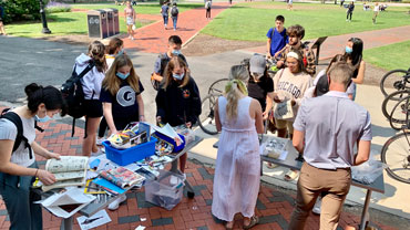 Students at a button-making event in front of the library
