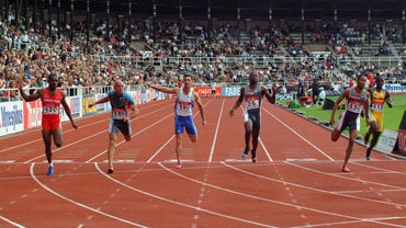 Sprinters in a race crossing a finish line.