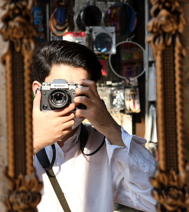 Man with a camera taking a self portrait in a mirror