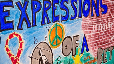 A close-up of a colorful mural with text "Expressions of a Better Georgetown," a peace sign, and other sociopolitical symbols.