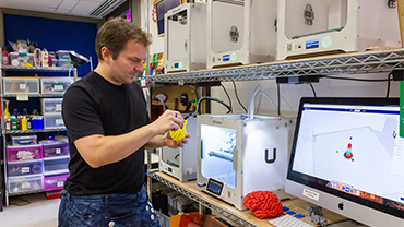 a man in the Maker Hub measuring a 3d printed part