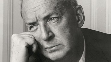 A black and white portrait of author Vladimir Nabokov looking out a window.