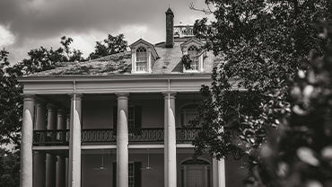 A black and white picture of a southern plantation.