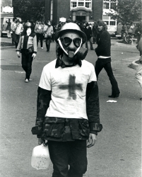 Black and white photograph of student medic wearing a gas mask