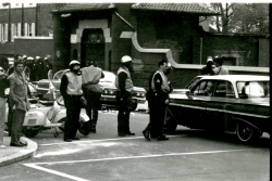 Black and white photograph of police stopping a car at the corner of 36th and Prospect streets and talking to the driver