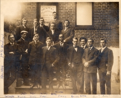 Sepia-toned photograph showing 15 students posed outside the Medical School. An African American student is seen in the center of the image