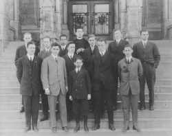 Black and white photograph showing 12 members of the Drama Club standing in the steps to Healy Hall