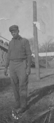 Black and white photograph of Theodore Woodward standing on the edge of an athletic field