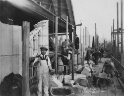 Black and white photograph of stone masons and supervisors on scaffolding