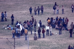 Color photograph of protesters on the athletic field