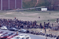 Color photograph of protesters massed at the south end of the athletic field