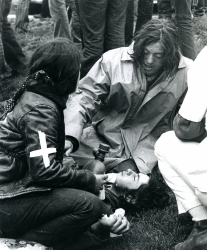 Black and white photograph of two student medics treating an injured man