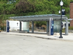 Color photograph showing the WWII memorial behind a campus bus shelter
