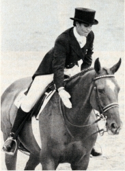 Black and white photograph of Marian Cunningham patting the neck of her horse