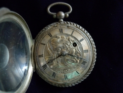 Silver pocket watch, open to show watch face with its repoussé scene of The Annunciation