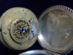 Silver pocket watch, open to show the movement