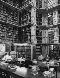 Black and white photograph showing men and women students studying in the Library