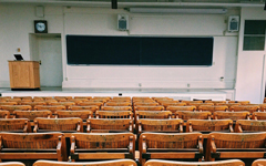Lecture hall with a blackboard, lectern, and rows of seats