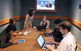 Six students study around a table in the Millennium Room