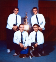 a photograph of Hoya the fourth, dog mascot, posing with four Georgetown cheerleaders and a trophy