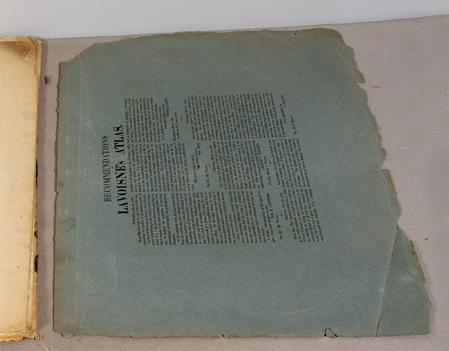 green book wrapper with printed text before conservation treatment