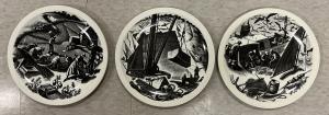 Three plates with black and white decoration are shown in a line. The leftmost plate portrays workers toiling in a field; the middle displays a crane-like apparatus lifting a block out of the side of a mountain while workers give direction underneath; the last plate shows figures hauling fish onto a boat while a pack of seagulls flies above them..
