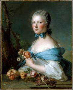 Portrait of a woman with a blue shawl holding flowers and smiling.