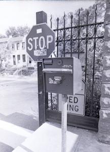 Black and white photograph showing a ticket machine standing by the main gates