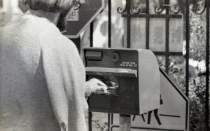 Black and white photograph showing a student buying a GUTS bus ticket