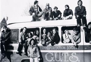 Members of GUTS posed in and on a GUTS bus