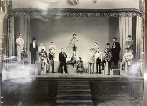 Cast standing on a play in various costumes