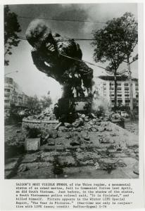 Image of a black and white photo of war scene in Vietnam with a statue of a US soldier being toppled. No people visible.