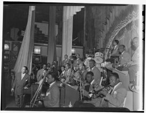 Black and white photo of band led by Duke Ellington facing photographer on their left