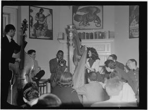 B X W photo of band in living area with cellist on left, man with horn, and woman with harp;