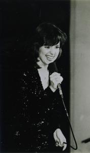 Picture of singer wearing a sequined dress holding a microphone