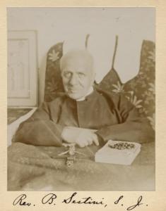 Photograph of Rev. B. Sestini at his desk with a book