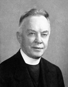 Yearbook photo of John O'Connor, a middle aged priest with gray sideburns wearing a black coat and a tall white collar