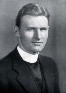 Philip Hurley, a young priest wearing a dark coat and a tall white collar
