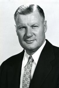 Philips Temple, with slicked back parted hair, wearing a sportscoat and tie
