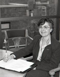 Sue Martin sits at a table in her office while writing on a notepad