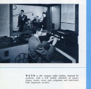 Black and white photograph of a radio station studio with a student at a set of control