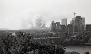 Black and white photograph looking across the river to Virginia. Billowing white smoke can be sign rising from the Pentagon