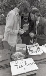 Black and white photograph showing table at Pandamedia with WGTB t-shirts for sale.