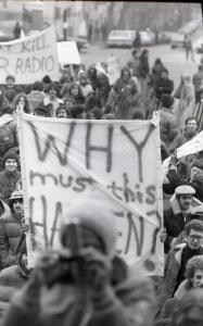 Black and white photograph showing students protesting in the rain, holding signs saying things like "Disco Sucks. GTB Lives" and "Don't Kill Our Radio."