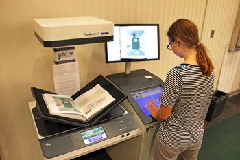 A student using the Library's book scanner